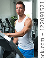 Young muscular man on treadmill in the gym 122091521