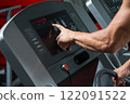 Male hands on control panel of cardio machine 122091522