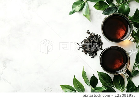 Two cups of black tea with dried tea leaves and green tea leaves on marble 122091953