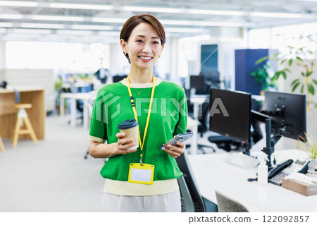 Business woman looking at a smartphone in the office 122092857