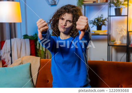 Displeased upset young woman showing thumbs down dislike gesture expressing discontent disapproval 122093088