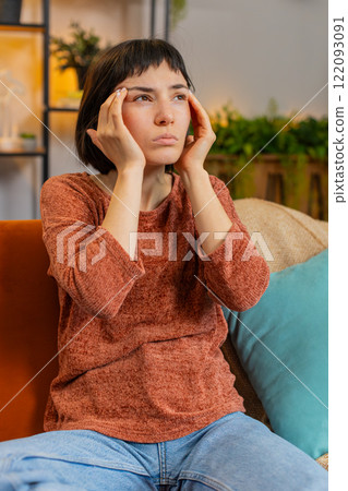 Woman rubbing temples to cure headache problem suffering from tension and migraine stress pain 122093091