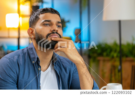 Thoughtful Indian man freelancer thinking about an important creative project work decision at home 122093102