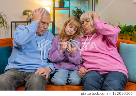 Child girl granddaughter grandfather grandmother playing game on smartphone losing fail at home 122093105