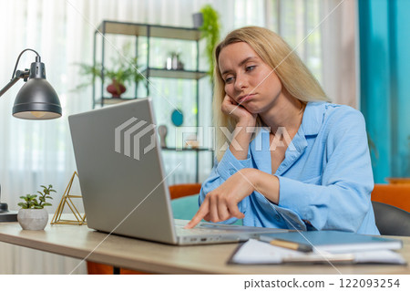 Bored sleepy tired businesswoman worker working on laptop leaning on hand at home office desk Bored sleepy tired businesswoman worker working on laptop leaning on hand at home office desk 122093254