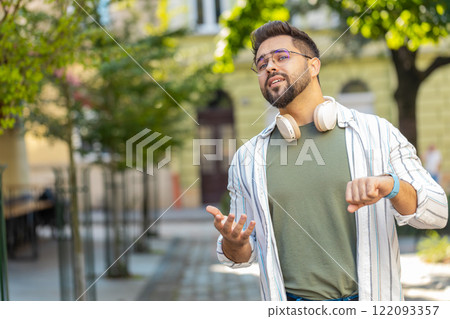 Man looking for someone waiting for meeting angry frustrated look time touching wristwatch on street Man looking for someone waiting for meeting angry frustrated look time touching wristwatch on street 122093357