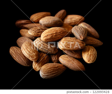 香烤杏仁的特寫照片,黑色背景上的切口 香烤杏仁的特寫照片,黑色背景上的切口 122093428