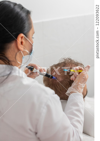 Trichologist doing man improve hair growth procedure, dermapen microneedling, vitamin injections 122093622