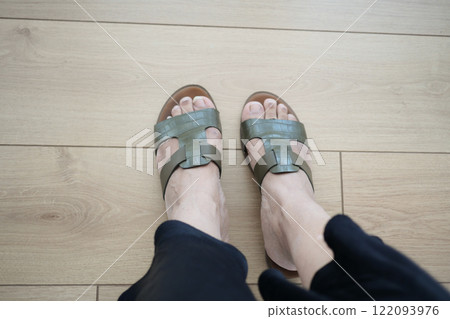 Stylish and Elegant Green Sandals Displayed on a Beautiful Wooden Floor 122093976