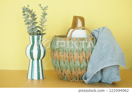 Eco-Friendly Woven Basket with Household Items and Cloth on Vibrant Background Eco-Friendly Woven Basket with Household Items and Cloth on Vibrant Background 122094062