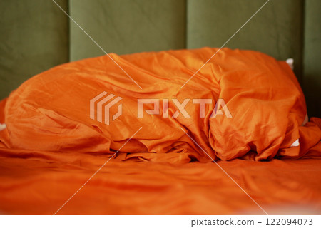 Cozy Orange Bedding with Textured Fabric and Green Background Cozy Orange Bedding with Textured Fabric and Green Background 122094073