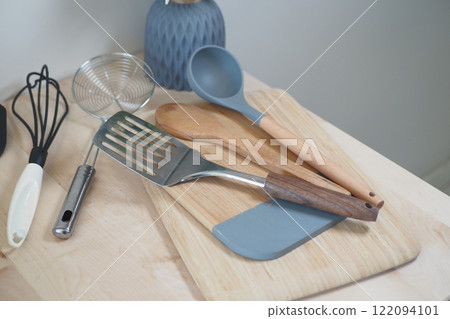 A Variety of Assorted Kitchen Utensils Arranged on a Wooden Cutting Board 122094101