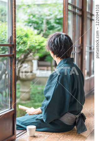 Asian man in yukata sitting on the veranda of a Japanese house (back view) Asian man in yukata sitting on the veranda of a Japanese house (back view) 122094318