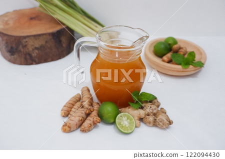 Ginger juice with fresh ginger and lemon on white background. Healthy drink. Ginger juice with fresh ginger and lemon on white background. Healthy drink. 122094430
