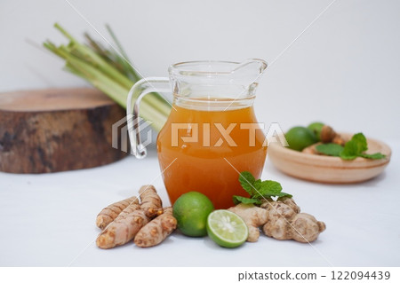 Ginger juice with fresh ginger and lemon on white background. Healthy drink. Ginger juice with fresh ginger and lemon on white background. Healthy drink. 122094439