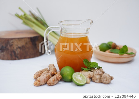 Ginger juice with fresh ginger and lemon on white background. Healthy drink. Ginger juice with fresh ginger and lemon on white background. Healthy drink. 122094440