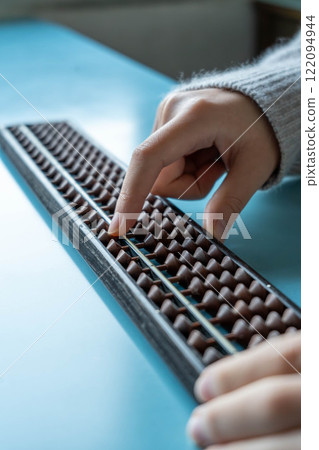 The hands of someone just starting to learn abacus The hands of someone just starting to learn abacus 122094944