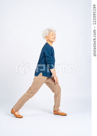 Full body photo of a senior woman doing exercises 122095194