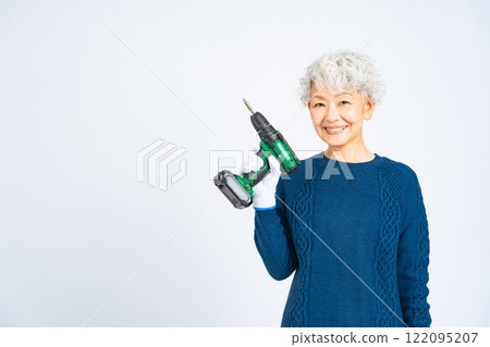 Senior woman with an electric screwdriver 122095207