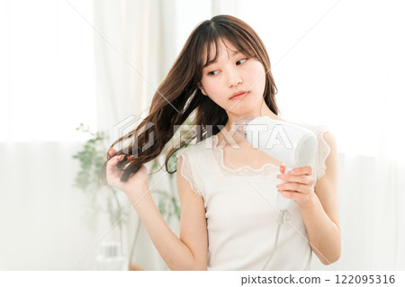 女人用吹風機吹乾頭髮（護髮） 122095316