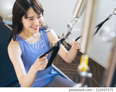 Woman doing machine pilates training 122097575