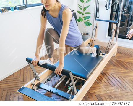 Woman doing machine pilates training 122097577