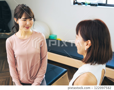 A woman receiving counseling from an instructor at the gym 122097582