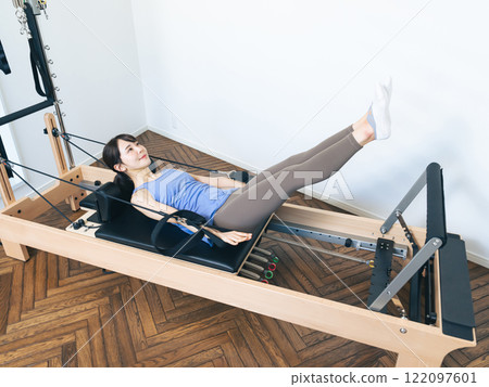 Woman doing machine pilates training 122097601