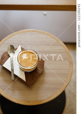 Cup of milk dirty coffee on table by the window. 122100242