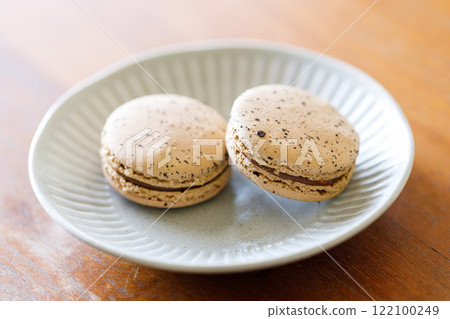 Brown orange Ceylon black tea flavor macaron on wooden table. 122100249