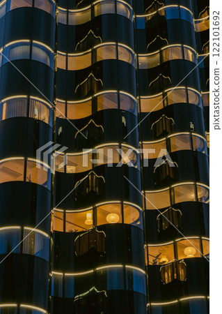 A modern building with a shining, curved glass façade 122101692