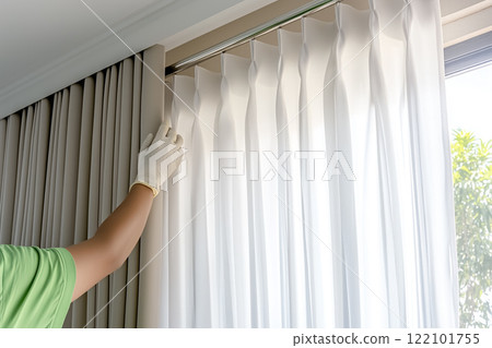 Technicians Install Window Curtain Rods for Stylish Home Decor in Bright Modern Interior 122101755
