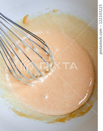 Mixing ingredients with whisk in bowl for baking 122103225