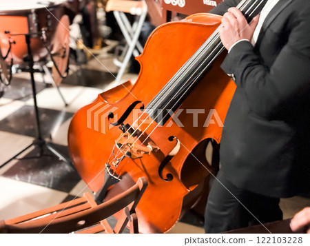 Male musician playing cello at indoor classical music performance Male musician playing cello at indoor classical music performance 122103228