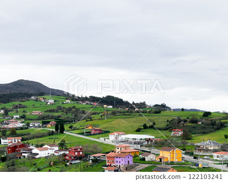 Scenic rural village landscape with colorful houses and rolling green hills Scenic rural village landscape with colorful houses and rolling green hills 122103241