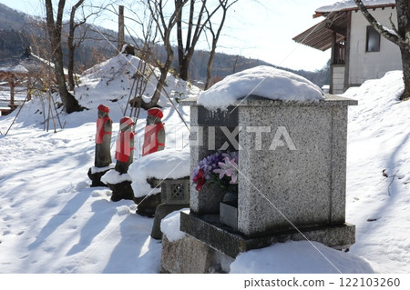 Jizo statue standing on the snow-covered shore of Lake Nakatsuna 122103260