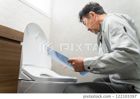 Repairman inspecting the toilet Lifestyle image 122103397