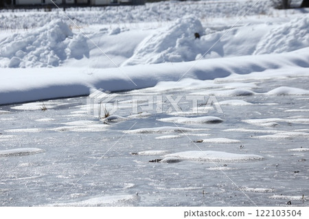 Snow piled up on a rice field filled with water 122103504