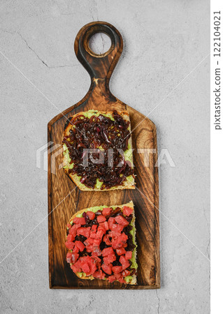 Unique toast creations with avocado, onion jam, and smoked salmon on a wooden board Unique toast creations with avocado, onion jam, and smoked salmon on a wooden board 122104021