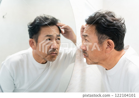 Middle-aged man checking his hair Beauty image 122104101