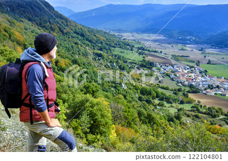 Hiker Admiring Scenic Landscape from a Mountain Viewpoint. Hiker Admiring Scenic Landscape from a Mountain Viewpoint. 122104801