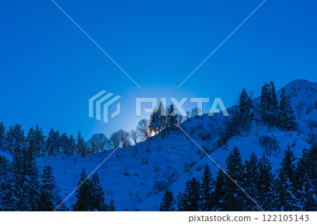 The sun rising over the snowy mountains (the morning sun illuminates the ridgeline) 122105143