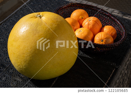 A beautiful still life of a large Banpeiyu and oranges in a basket 122105685