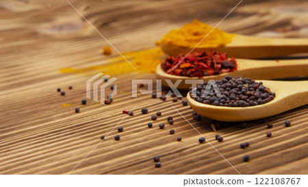 Dry different spices in spoons on wooden background Dry different spices in spoons on wooden background 122108767