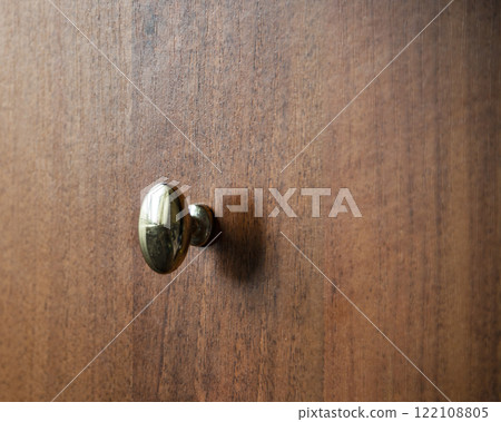 Door metalic knob on brown wooden background 122108805