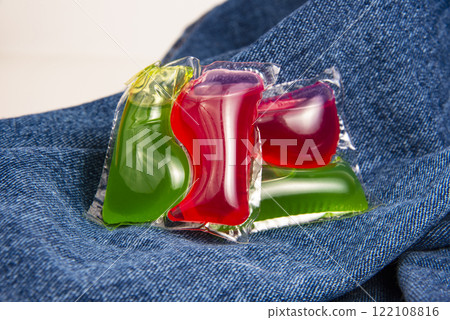 Red green capsule for cloth washing liquid powder on cotton denim background Red green capsule for cloth washing liquid powder on cotton denim background 122108816
