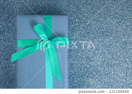 Craft gift box blue color bow on shiny background with copyspace Craft gift box blue color bow on shiny background with copyspace 122108848