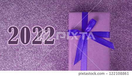 2022 Craft gift box purple color bow on shiny background with copyspace 2022 Craft gift box purple color bow on shiny background with copyspace 122108861