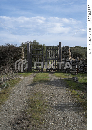Rustic wooden gate with dry stone wall in a rural countryside 122108885