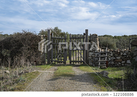Rustic wooden gate with dry stone wall in a rural countryside 122108886